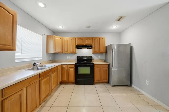 a kitchen with a refrigerator sink and cabinets