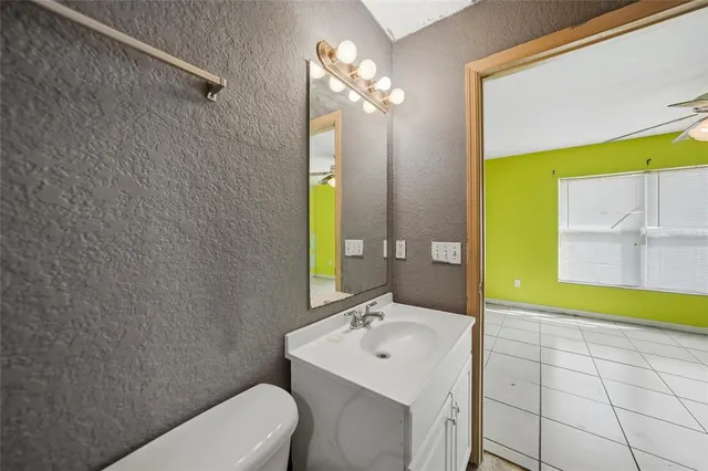 a bathroom with a sink a toilet and mirror