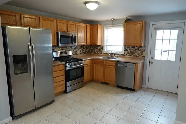 a kitchen with stainless steel appliances granite countertop a refrigerator a stove a sink and dishwasher