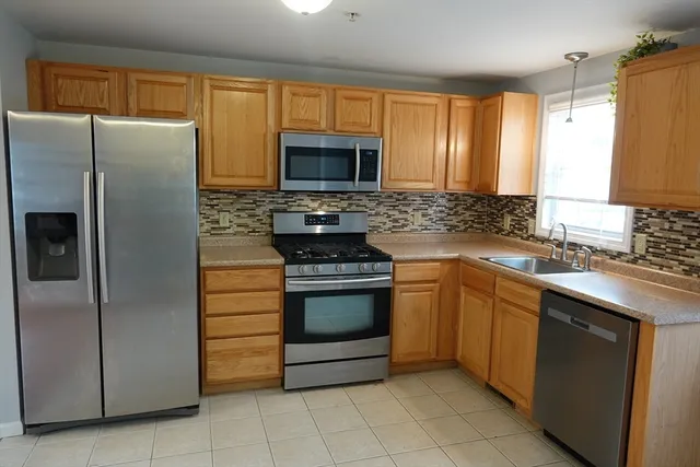 a kitchen with stainless steel appliances granite countertop a stove a refrigerator and a sink