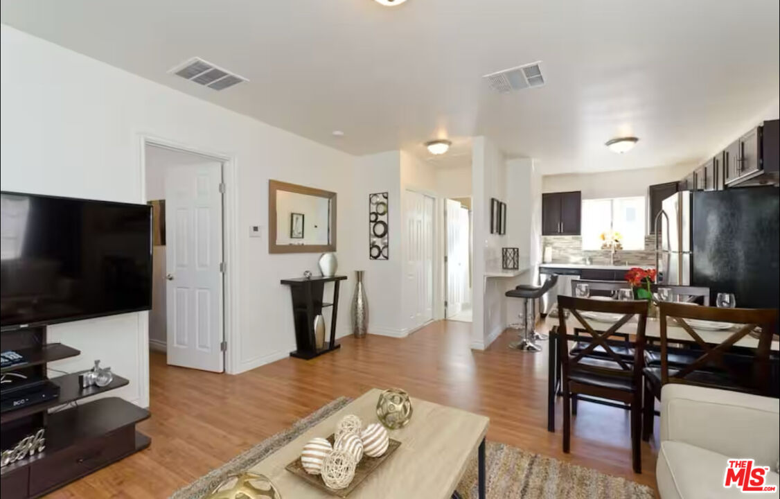 a living room with furniture wooden floor and a flat screen tv