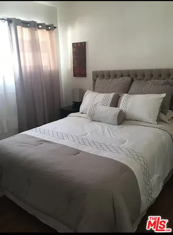 a bed sitting in a bedroom next to a window