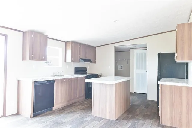 a kitchen with a sink a stove a refrigerator and cabinets