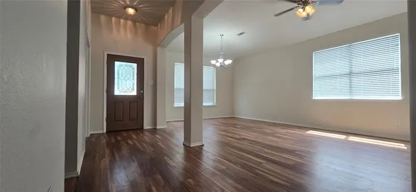 a view of an empty room with window and wooden floor