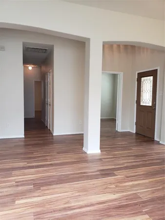 a view of an empty room with wooden floor and closet