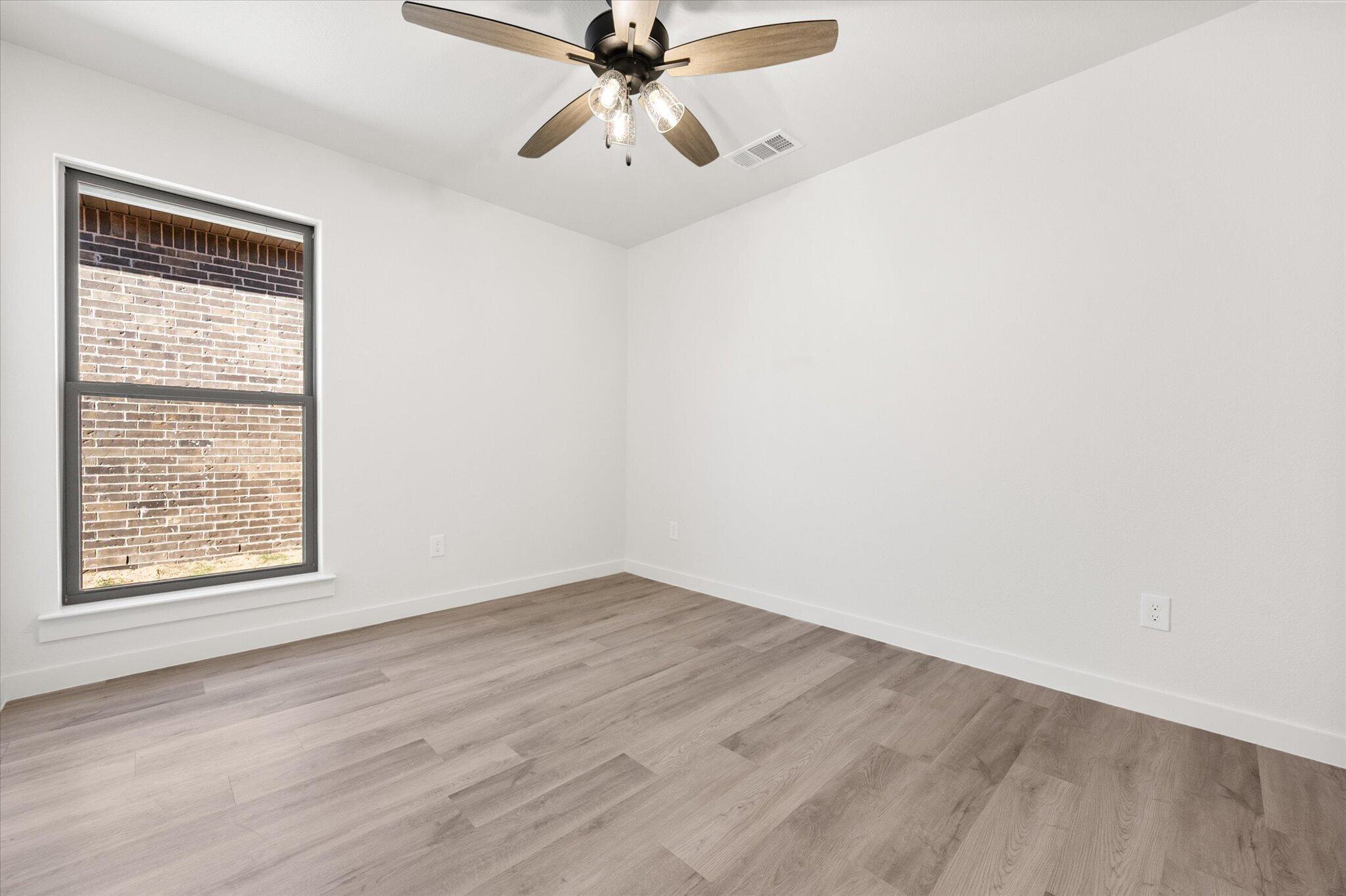 2403 Helena Avenue Lubbock, TX 79407 - Photo 20 of 25 an empty room with a window and a fan