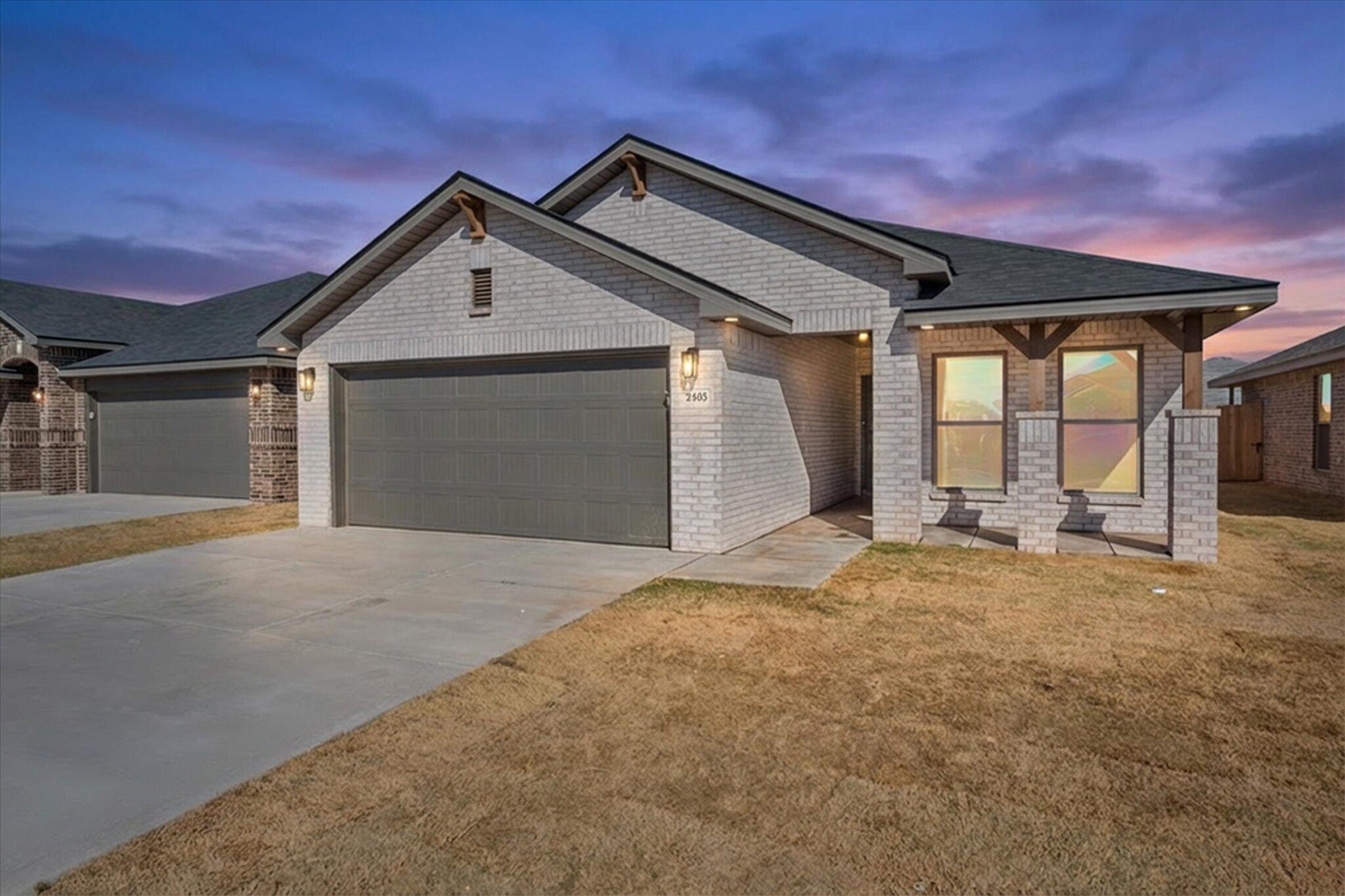 2403 Helena Avenue Lubbock, TX 79407 - Photo 2 of 25 a front view of a house with a yard and garage