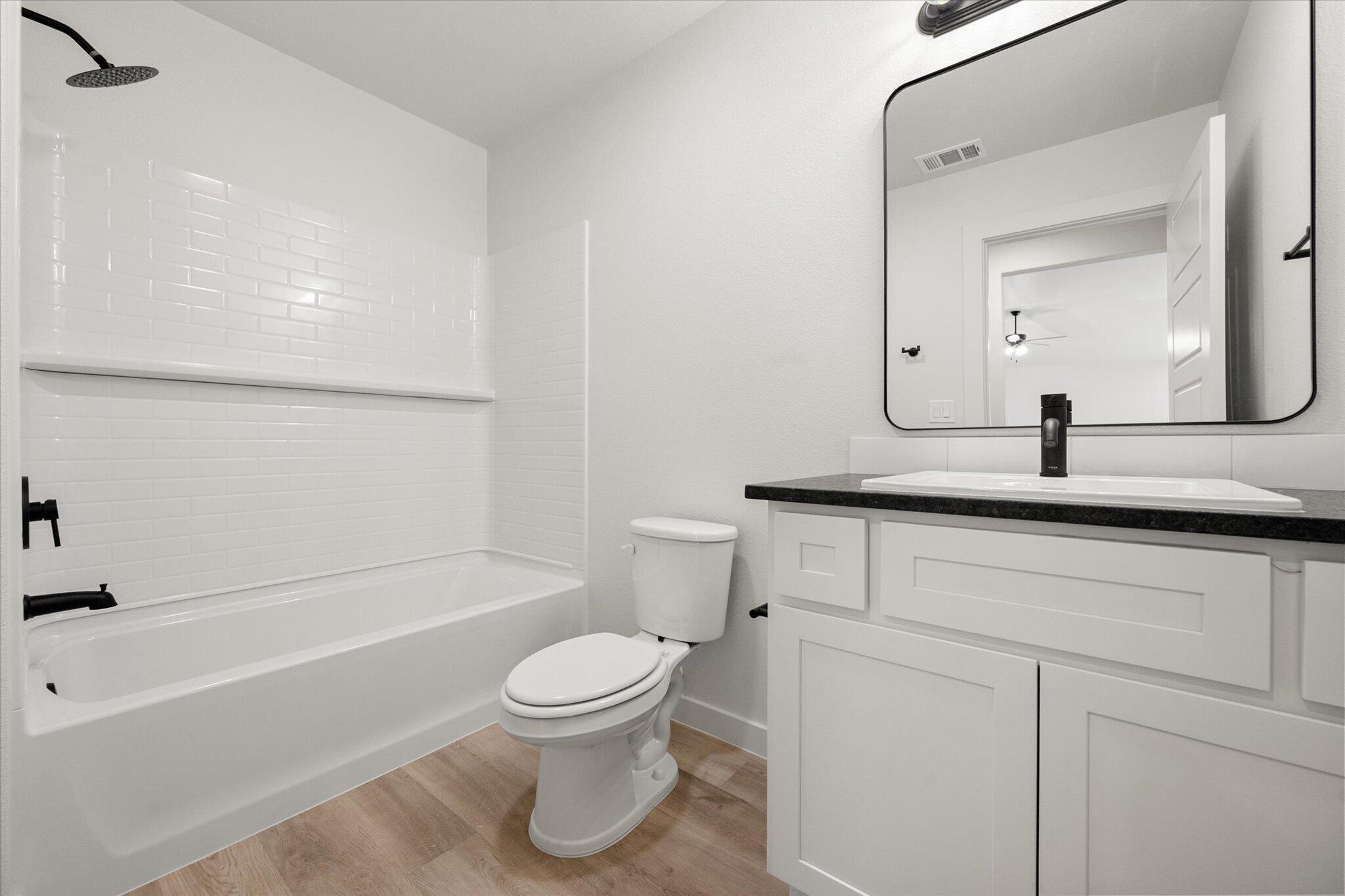 2403 Helena Avenue Lubbock, TX 79407 - Photo 23 of 25 a bathroom with a toilet a sink and bathtub