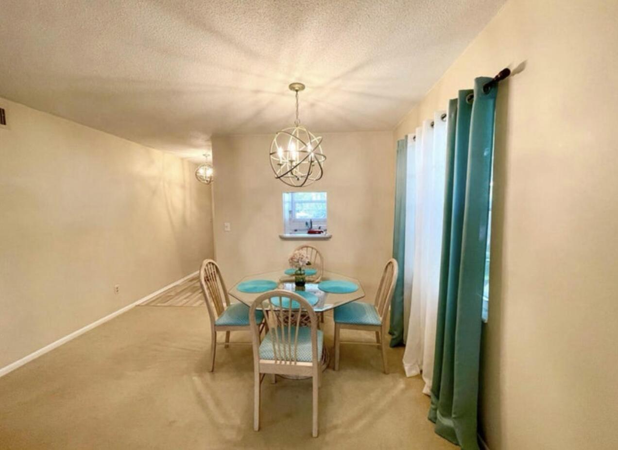2600 Southeast Ocean Boulevard, Unit A2 Stuart, FL 34996 - Photo 6 of 16 a dining room with furniture and a chandelier