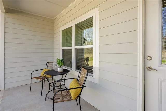 a patio with table and chairs and potted plants