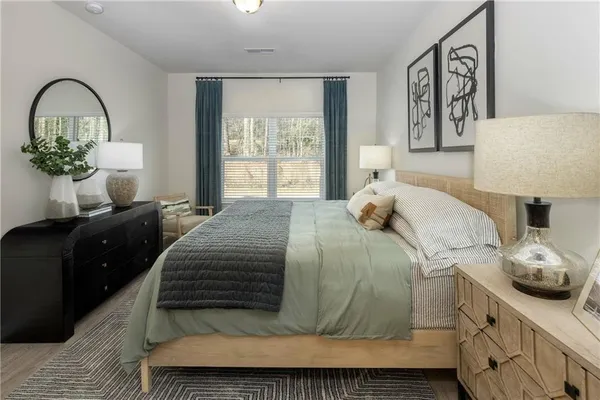 a bedroom with a bed and a potted plant on dresser