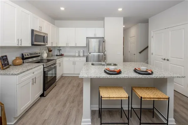a kitchen with a sink white cabinets and stainless steel appliances