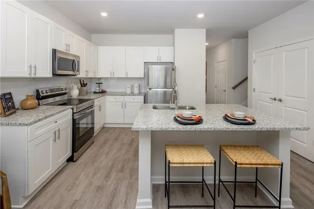 a kitchen with a sink white cabinets and stainless steel appliances