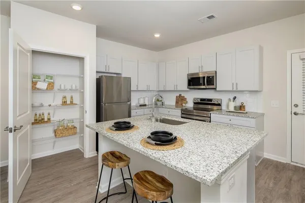 a kitchen with a stove a refrigerator and a dining table