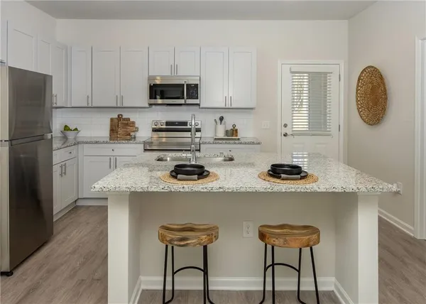 a kitchen with refrigerator a stove a sink and a cabinets