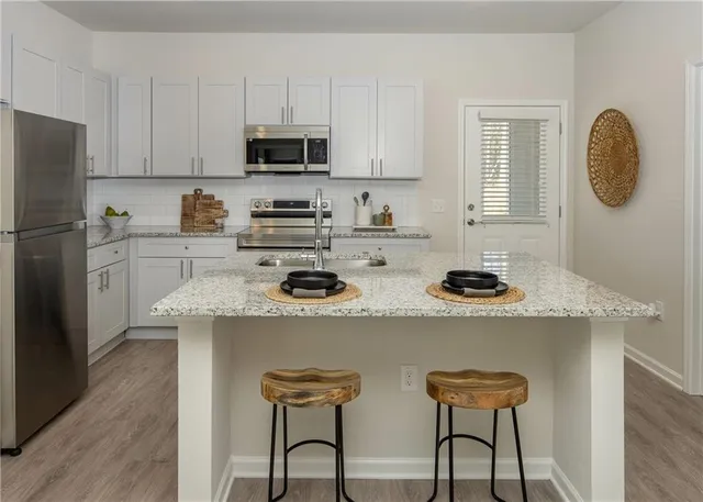 a kitchen with refrigerator a stove a sink and a cabinets