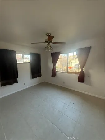 an empty room with windows and fireplace