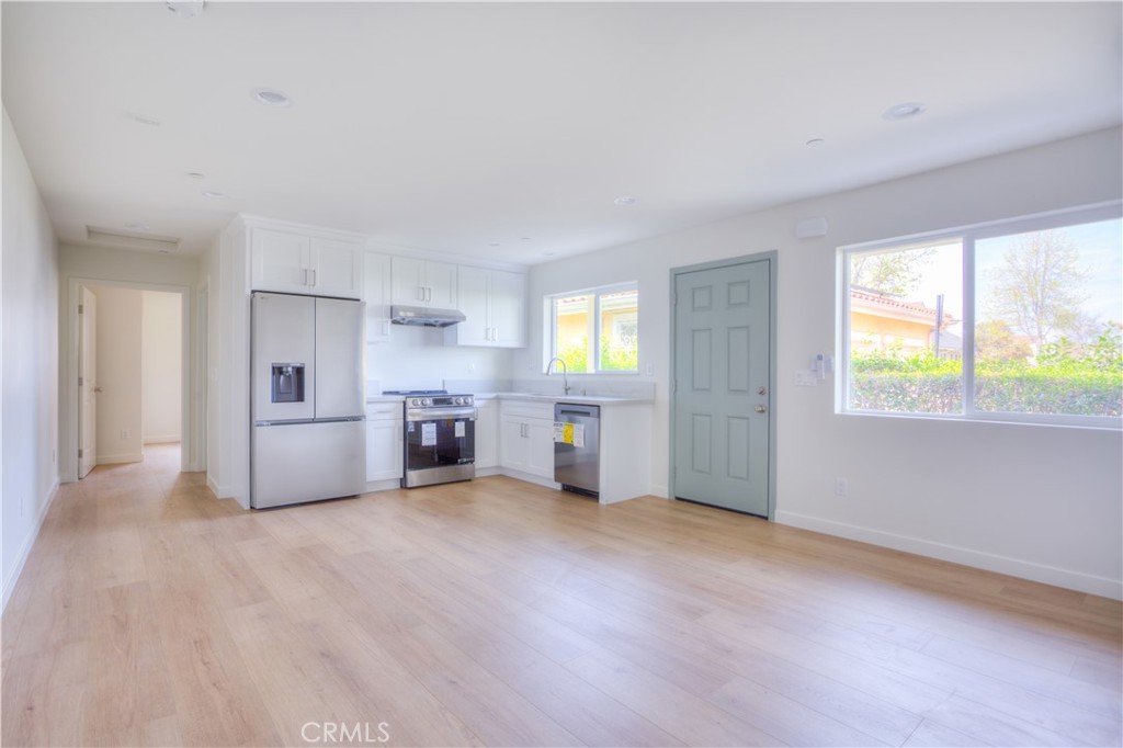 a view of a kitchen with furniture an empty room and windows