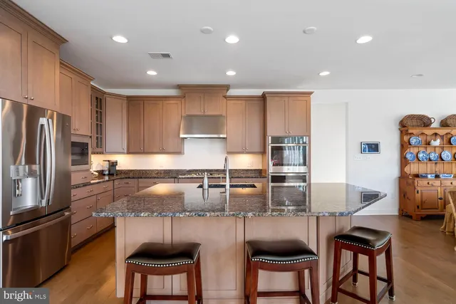 a living room with stainless steel appliances kitchen island granite countertop furniture and a window