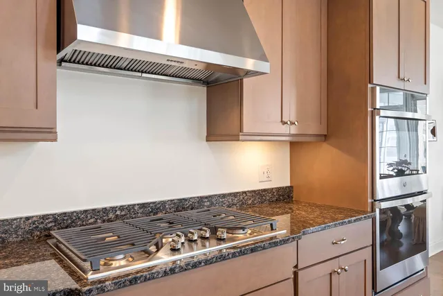 a bathroom with a granite countertop sink a mirror and a shower
