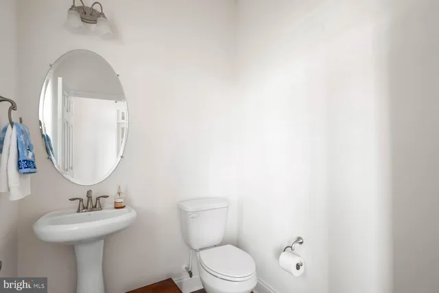 a bathroom with a granite countertop sink toilet and mirror