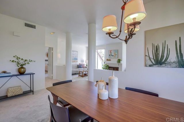 a dining room with wooden floor a chandelier a wooden table and chairs