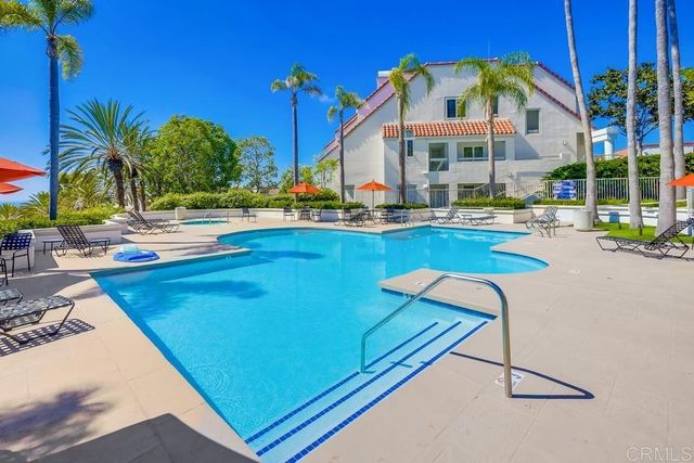 a view of a swimming pool with chairs in patio