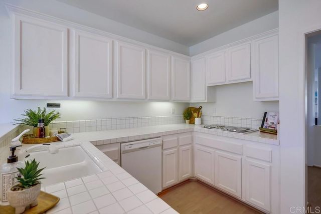 a kitchen with a white sink cabinets and a stove