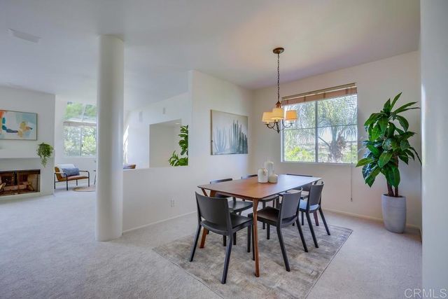 a dining room with furniture potted plants and a chandelier