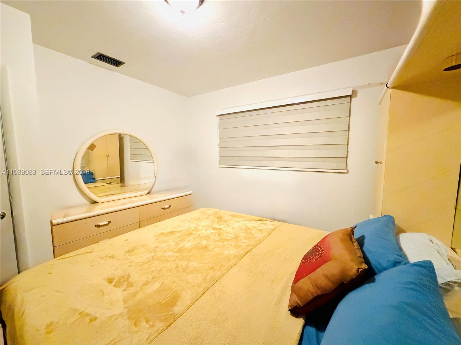 546 East 39th Street Hialeah, FL 33013 - Photo 11 of 24 a bed sitting in a bedroom next to a window