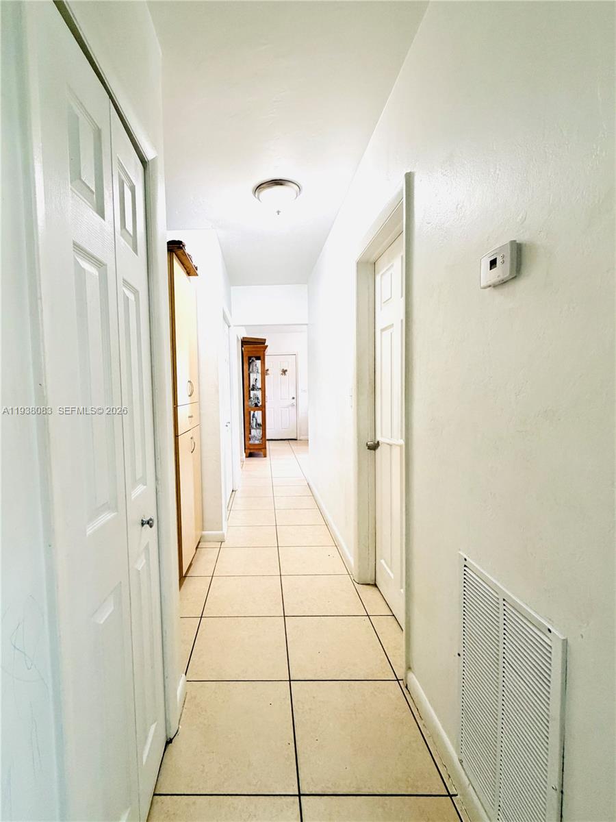 546 East 39th Street Hialeah, FL 33013 - Photo 12 of 24 a hallway with sliding door and windows