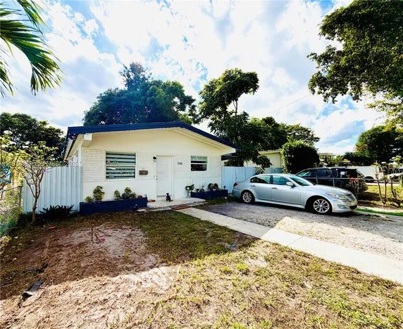 a view of a house with backyard and trees