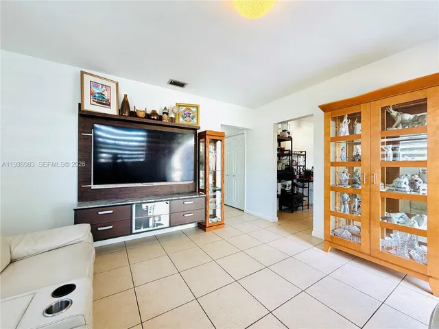 a living room with stainless steel appliances furniture and a flat screen tv