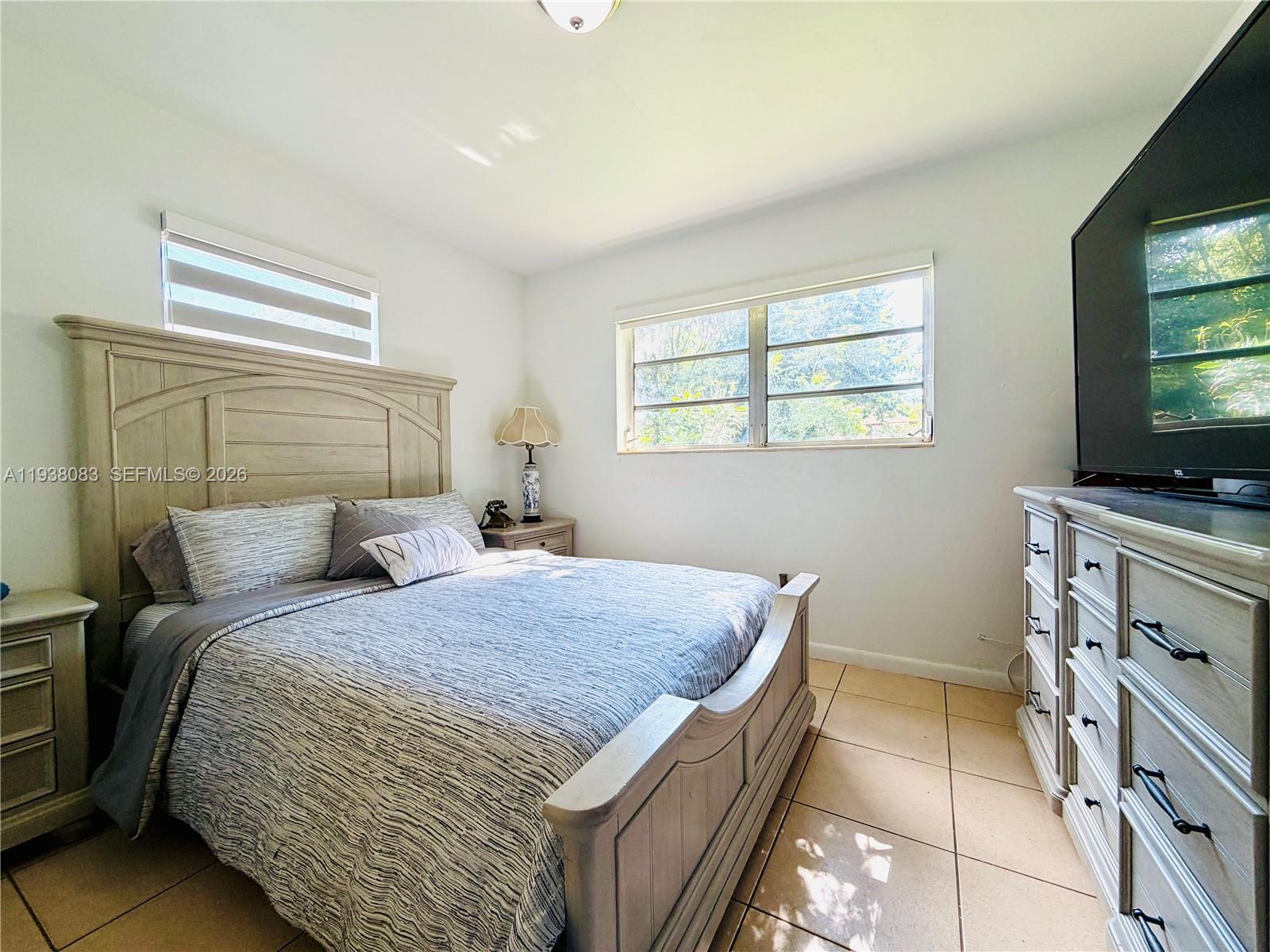 546 East 39th Street Hialeah, FL 33013 - Photo 9 of 24 a bedroom with a bed and a flat screen tv