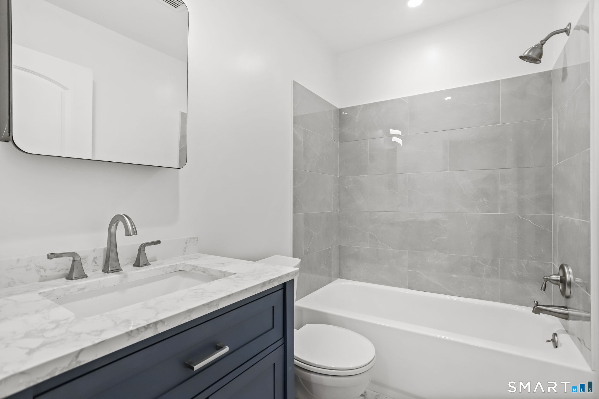 7 Hamilton Avenue, Unit 32 Norwalk, CT 06854 - Photo 11 of 14 a bathroom with a granite countertop sink a toilet and bathtub