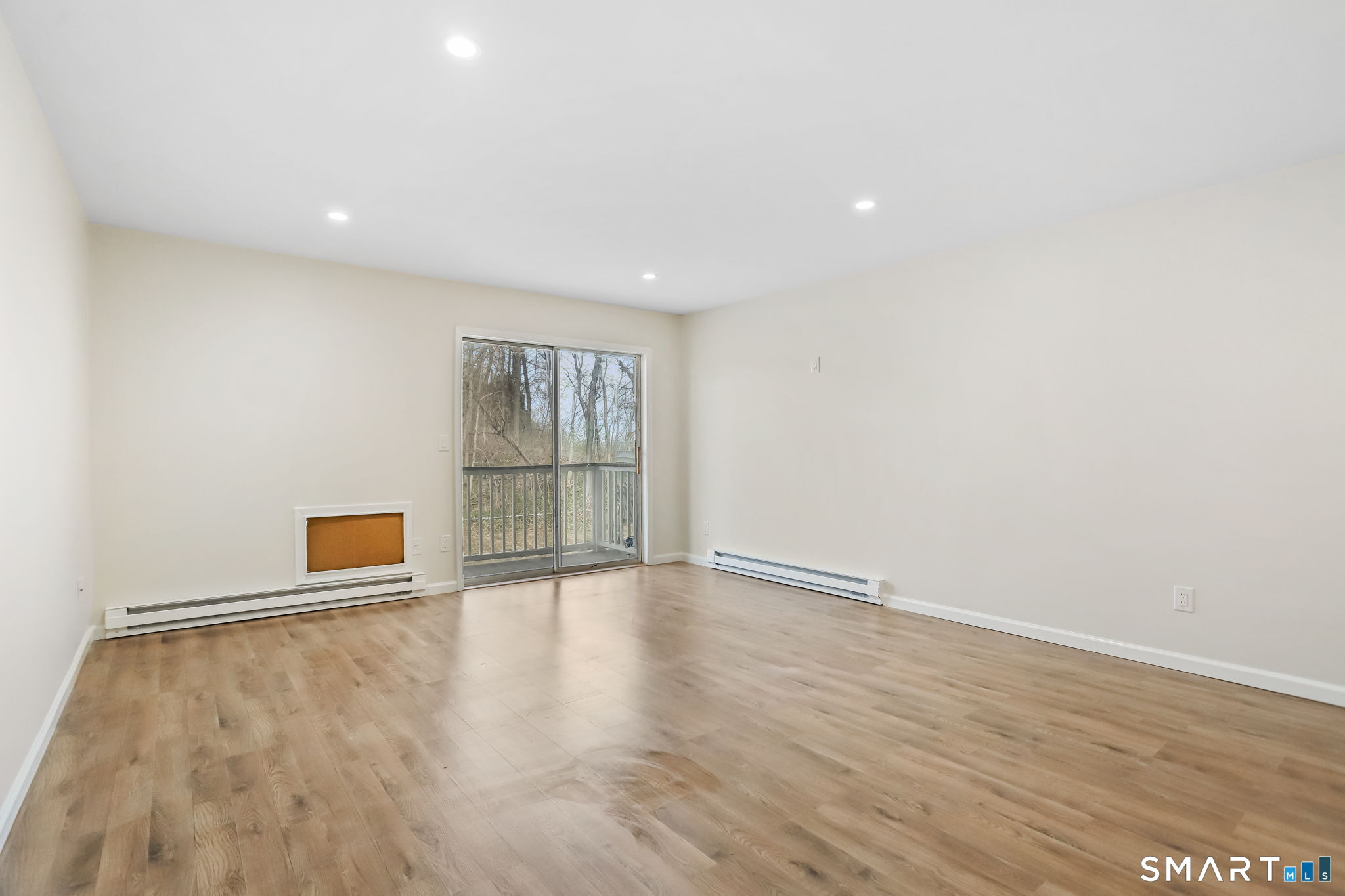 7 Hamilton Avenue, Unit 32 Norwalk, CT 06854 - Photo 3 of 14 a view of an empty room with wooden floor and a window