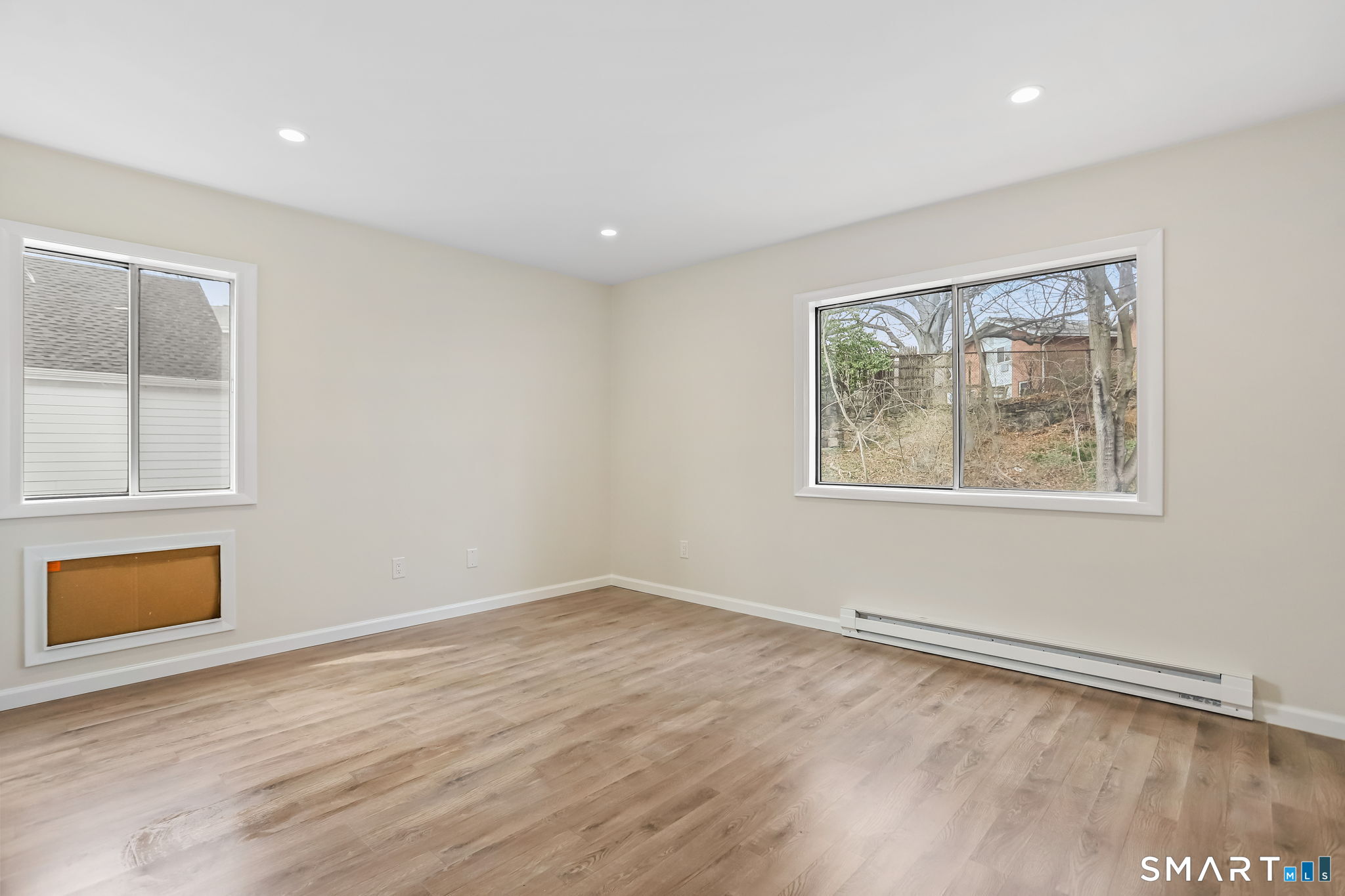 7 Hamilton Avenue, Unit 32 Norwalk, CT 06854 - Photo 7 of 14 a view of an empty room with wooden floor and a window