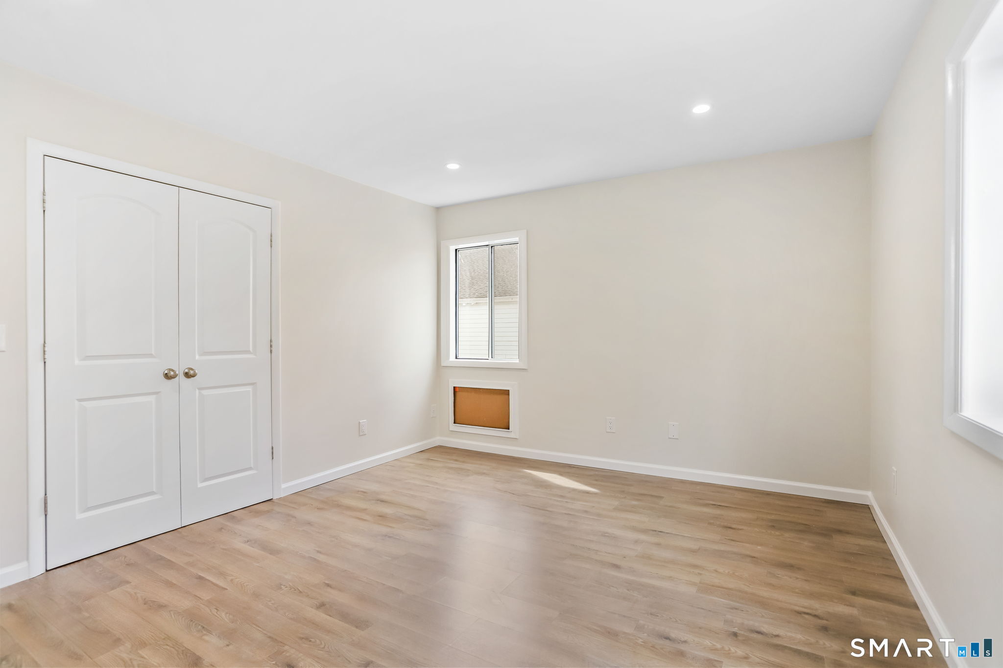 7 Hamilton Avenue, Unit 32 Norwalk, CT 06854 - Photo 9 of 14 a view of an empty room with wooden floor and a window