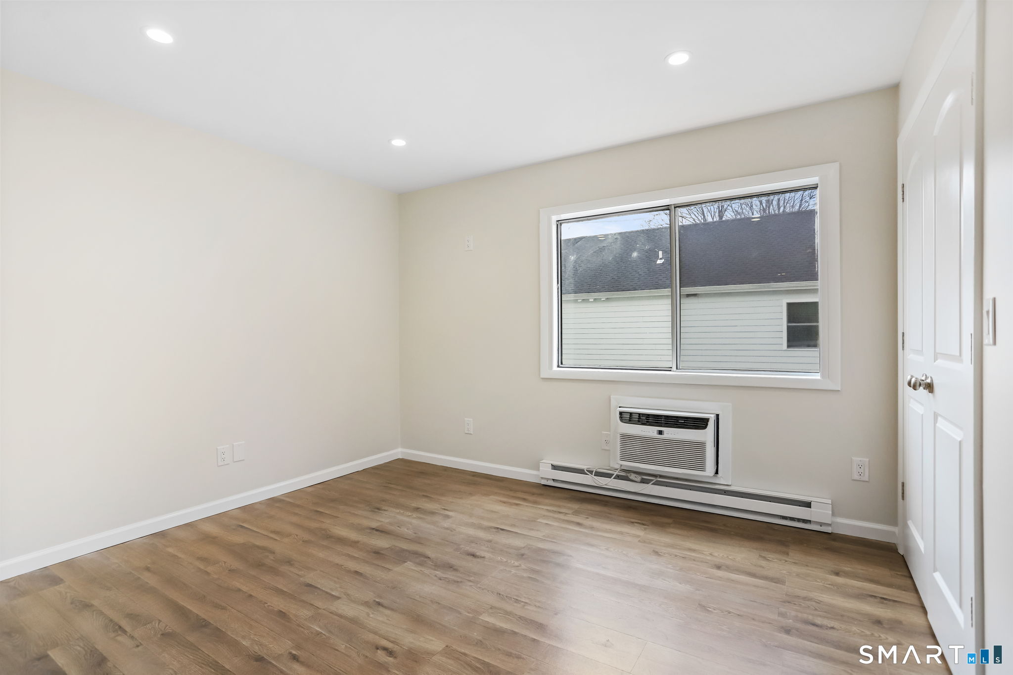 7 Hamilton Avenue, Unit 32 Norwalk, CT 06854 - Photo 10 of 14 an empty room with wooden floor and windows