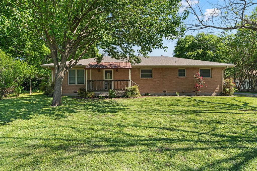 Rear view of house with brick siding and a lawn