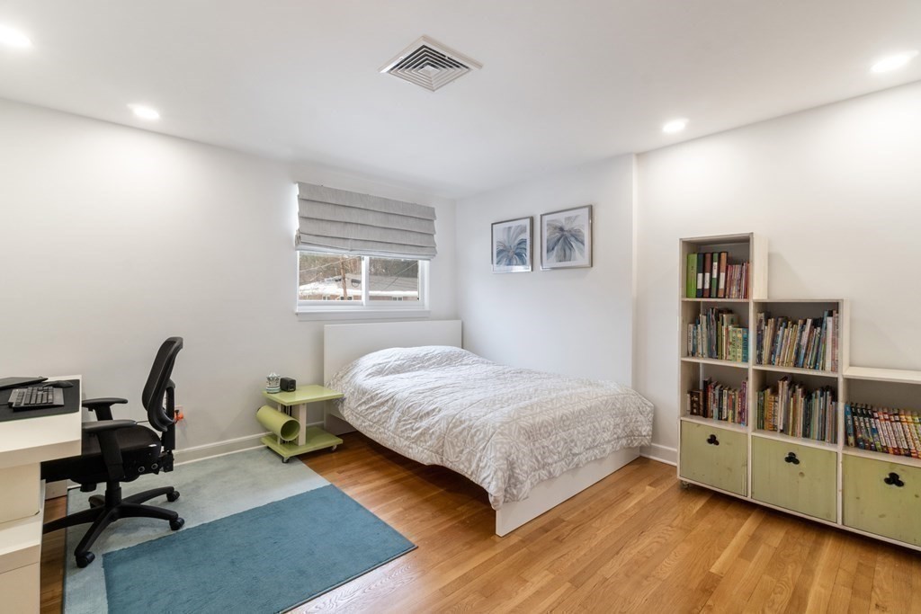 51 Donna Road Newton, MA 02459 - Photo 17 of 30 a bedroom with a bed a bookshelf and a chair