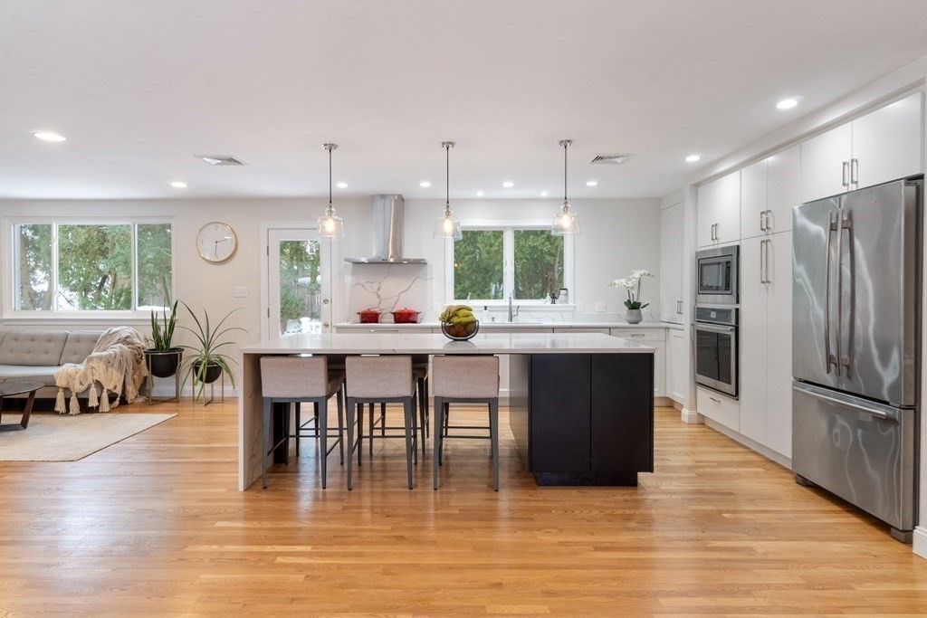 51 Donna Road Newton, MA 02459 - Photo 4 of 30 a kitchen with stainless steel appliances a dining table chairs stove refrigerator and cabinets