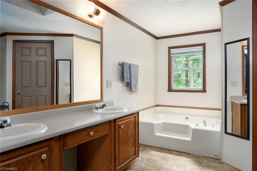 2103 Millcroft Road Pleasant Garden, NC 27313 - Photo 14 of 27 Primary ensuite features tub, separate shower, dual vanity and walk in closet