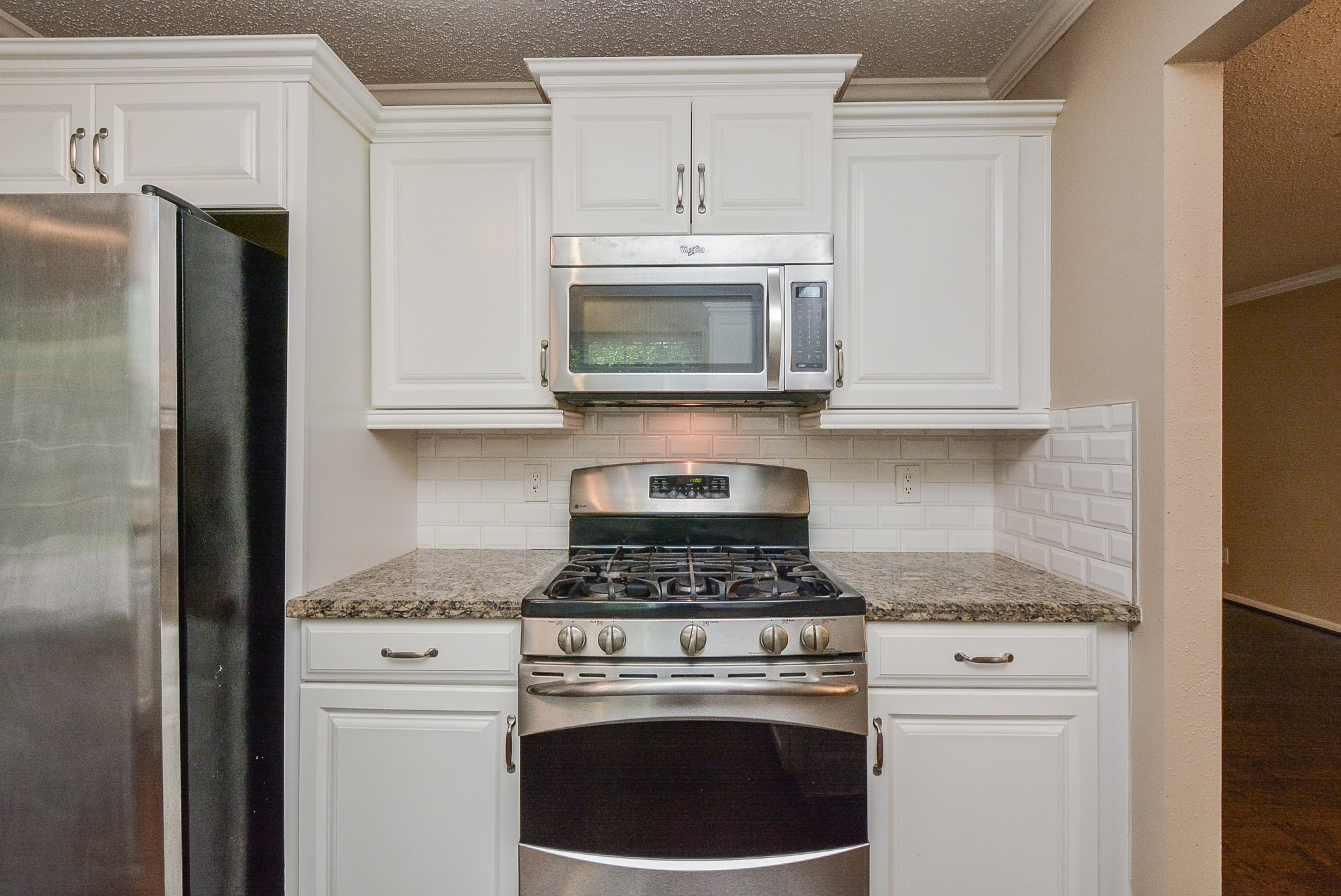 10 Ridgecross Place Spring, TX 77381 - Photo 10 of 32 a kitchen with granite countertop white cabinets and stainless steel appliances