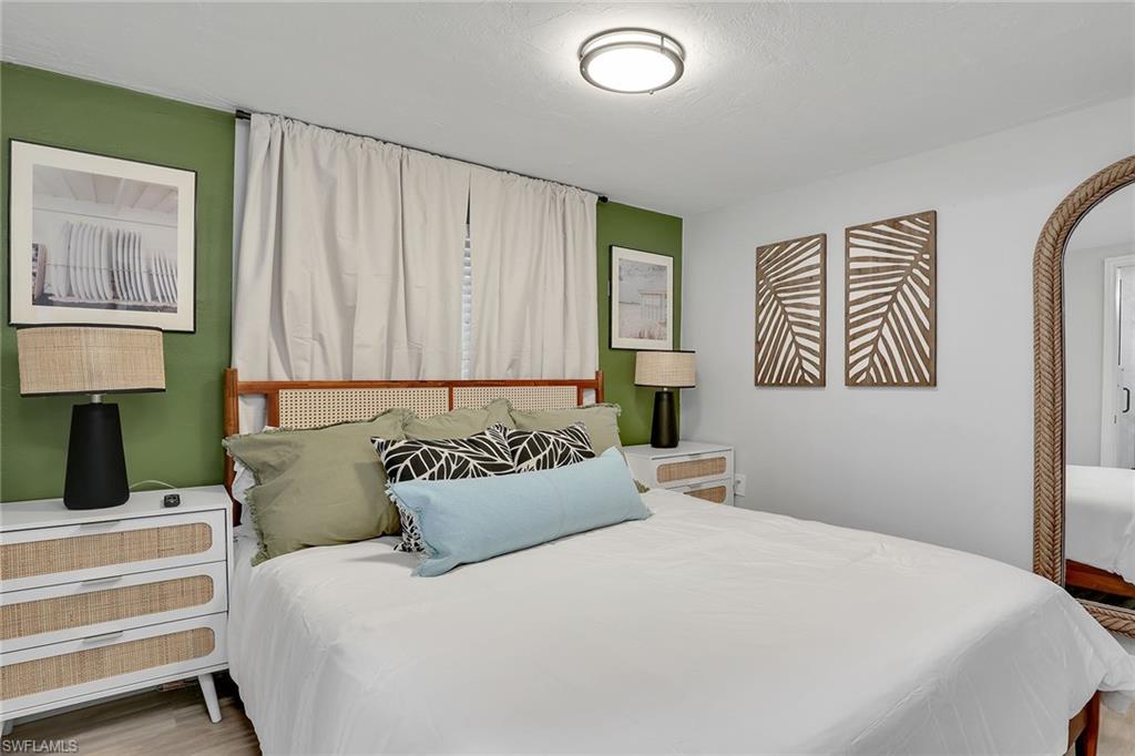 2780 Weeks Avenue Naples, FL 34112 - Photo 7 of 34 a bedroom with a large bed and a lamp