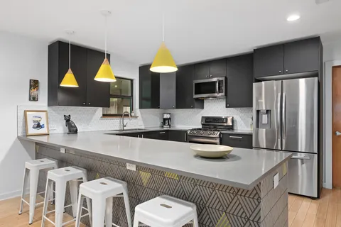 a kitchen with stainless steel appliances a sink a stove a refrigerator and cabinets