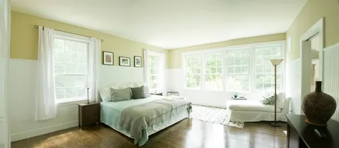 a spacious bedroom with a bed and a couch next to a window
