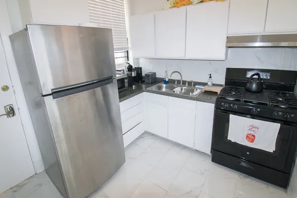 a kitchen with stainless steel appliances a refrigerator a sink a stove and cabinets