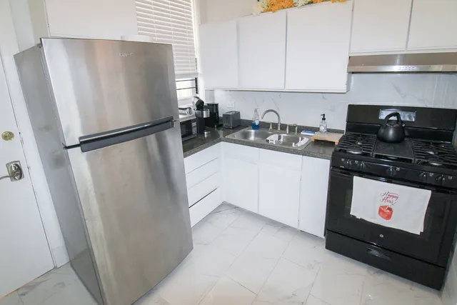 a kitchen with stainless steel appliances a refrigerator a sink a stove and cabinets