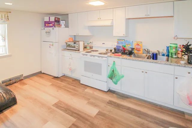 a kitchen with white cabinets and white appliances